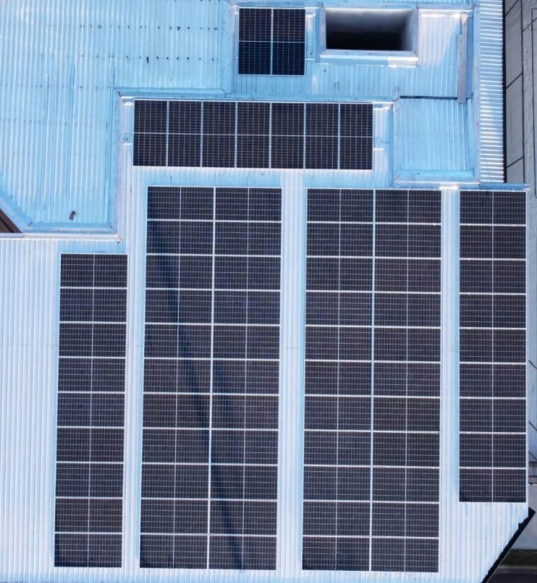 Vista aérea de vários painéis solares instalados em um telhado metálico