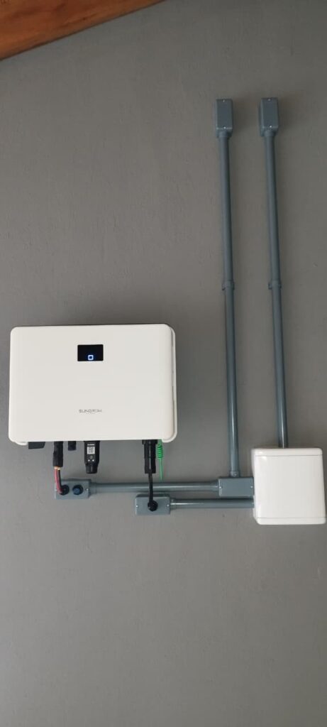 Inversor instalado na parede com eletrodutos cinza