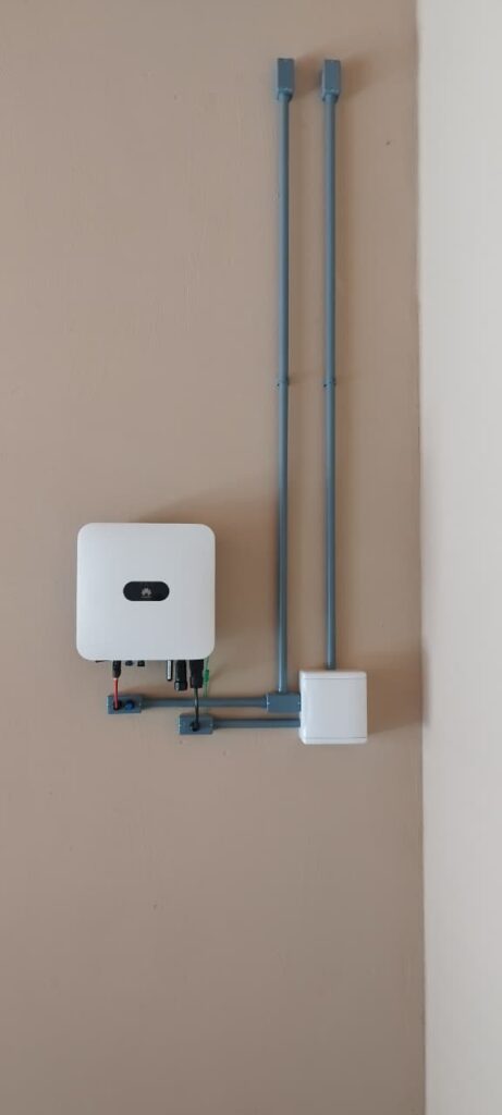 Inversor instalado em parede bege com eletrodutos cinza